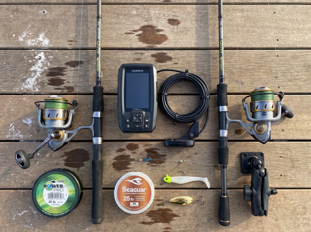Complete kayak inshore rigging setup flat lay showing St. Croix Avid Inshore rods, Penn Spinfisher reels, Garmin Striker sonar, PowerPro braid, and Seaguar fluoro